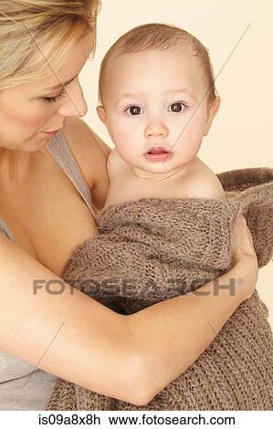 Stock Image - Mother with baby son wrapped in knitwear. Fotosearch