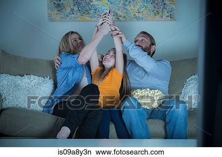 Parents and child fighting for remote control View Large Photo Image Picture - Parents and child fighting for remote control. Fotosearch