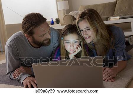 Stock Photo - Parents and child looking at laptop. Fotosearch