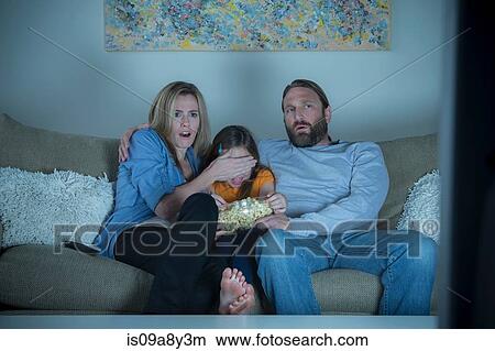 Parents and child watching horror movie View Large Photo Image Picture - Parents and child watching horror movie. Fotosearch