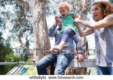 Parents swinging child by the arms View Large Photo Image Stock Photo - Parents swinging child by the arms. Fotosearch