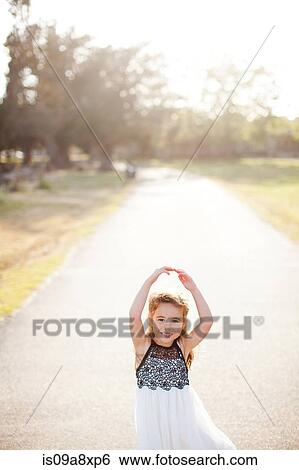 Portrait of girl on lane with arms above head View Large Photo Image Stock Photograph - Portrait of girl on lane with arms above head. Fotosearch