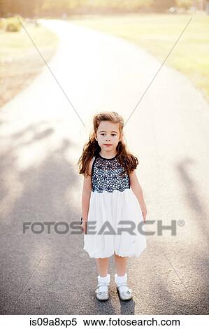 Stock Photography - Portrait of girl standing on lane. Fotosearch