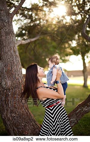 Stock Image - Portrait of mother holding baby daughter. Fotosearch