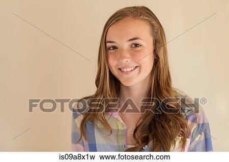 Stock Photo - Portrait of teenage girl with long brown hair, smiling. Fotosearch