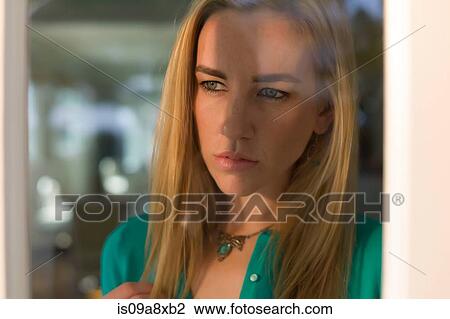 Portrait of young woman looking out of window View Large Photo Image Stock Image - Portrait of young woman looking out of window. Fotosearch