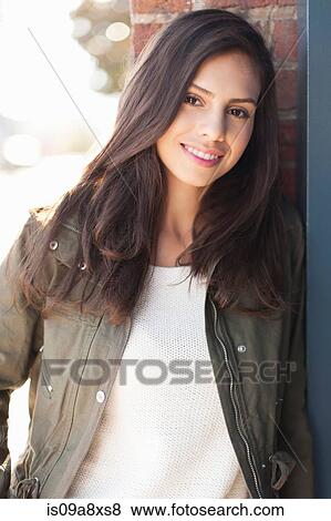 Stock Photo - Portrait of young woman with long brown hair, smiling. Fotosearch