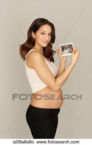 Picture - Pregnant woman holding ultrasound scan. Fotosearch