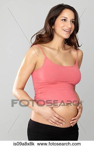 Stock Image - Pregnant woman touching stomach. Fotosearch