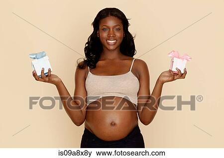 Stock Photo - Pregnant young woman holding blue and pink gift boxes. Fotosearch