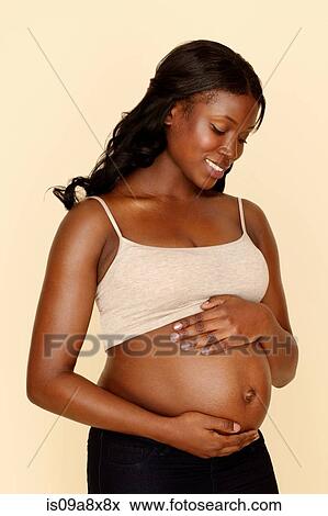 Stock Photo - Pregnant young woman touching stomach. Fotosearch