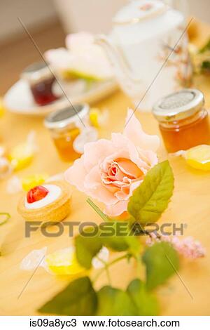 Rose on table with teatime treats and sweets View Large Photo Image Stock Image - Rose on table with teatime treats and sweets. Fotosearch