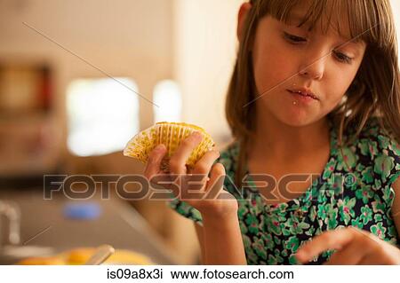 Stock Image - Sad girl holding cupcake. Fotosearch