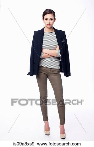 Studio portrait of young woman with arms folded View Large Photo Image Stock Photo - Studio portrait of young woman with arms folded. Fotosearch