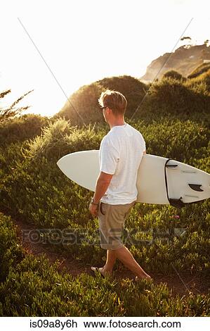 Surfer walking on pathway View Large Photo Image Stock Image - Surfer walking on pathway. Fotosearch