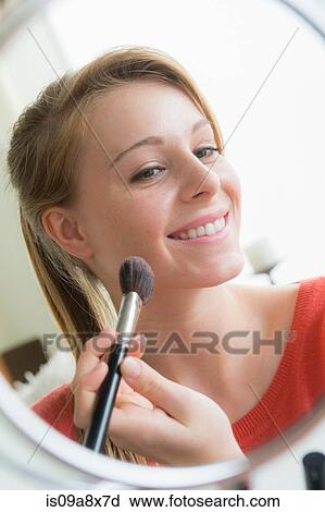 Stock Image - Teenage girl applying cosmetics. Fotosearch