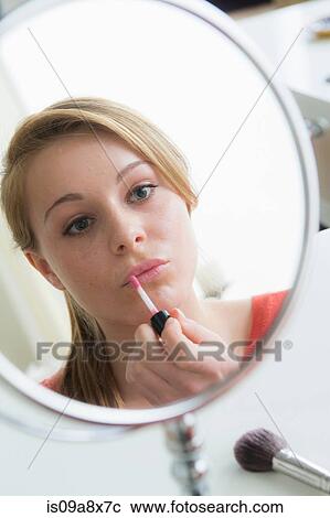 Stock Image - Teenage girl applying lip gloss. Fotosearch