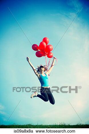 Teenage girl jumping in mid air holding red balloons View Large Photo Image Stock Image - Teenage girl jumping in mid air holding red balloons. Fotosearch