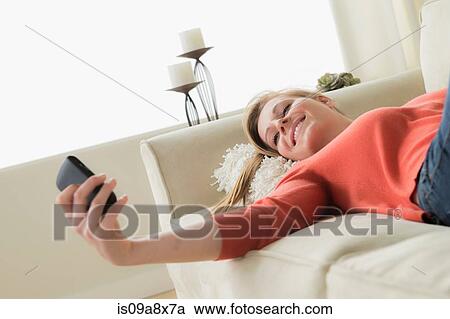 Teenage girl on sofa with cell phone, smiling View Large Photo Image Stock Image - Teenage girl on sofa with cell phone, smiling. Fotosearch
