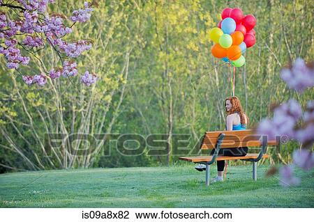 Teenage girl sitting on park bench with balloons View Large Photo Image Stock Image - Teenage girl sitting on park bench with balloons. Fotosearch