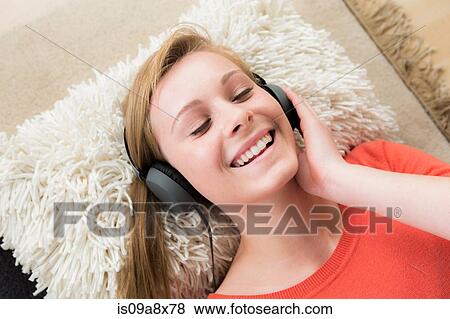 Stock Photo - Teenage girl wearing headphones with eyes closed. Fotosearch