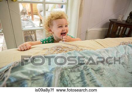 Toddler laughing at edge of bed View Large Photo Image Stock Image - Toddler laughing at edge of bed. Fotosearch