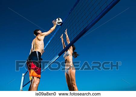 Two beach volleyball players blocking at net View Large Photo Image Stock Image - Two beach volleyball players blocking at net. Fotosearch