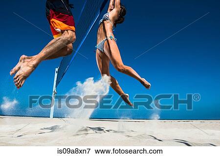 Two beach volleyball players blocking at net View Large Photo Image Stock Photo - Two beach volleyball players blocking at net. Fotosearch
