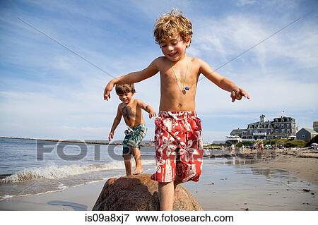 Stock Photo - Two boys playing on beach. Fotosearch