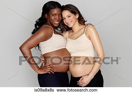 Stock Photograph - Two pregnant women with arms around each other. Fotosearch