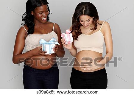 Stock Photograph - Two pregnant women with pink and blue gift boxes. Fotosearch