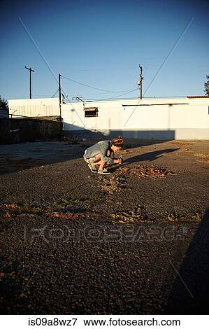 Woman bending down to take photograph View Large Photo Image Stock Photo - Woman bending down to take photograph. Fotosearch
