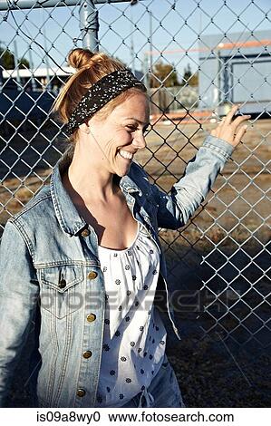 Woman holding fence and smiling View Large Photo Image Stock Image - Woman holding fence and smiling. Fotosearch