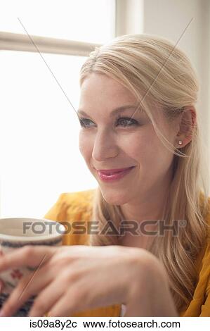 Stock Image - Woman holding tea cup. Fotosearch