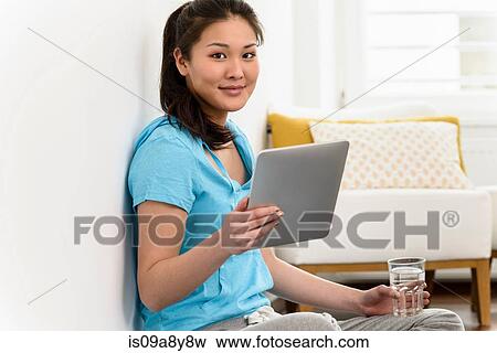 Stock Photo - Woman holding up digital tablet. Fotosearch