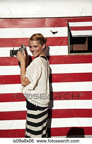 Stock Photograph - Woman holding vintage camera. Fotosearch