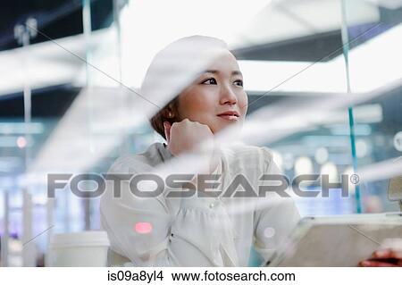 Picture - Woman in cafe looking into distance. Fotosearch