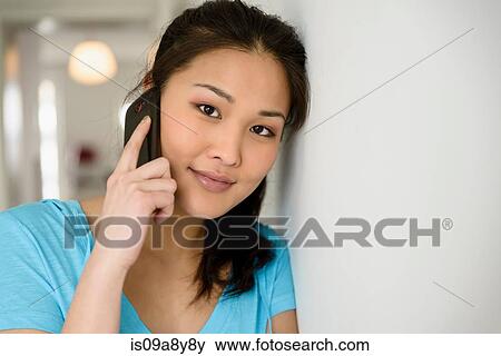 Woman leaning head against wall on phone View Large Photo Image Stock Photo - Woman leaning head against wall on phone. Fotosearch