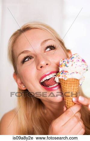 Stock Image - Woman licking ice cream. Fotosearch