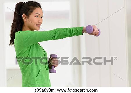 Woman lifting dumbbell with one arm forward View Large Photo Image Picture - Woman lifting dumbbell with one arm forward. Fotosearch