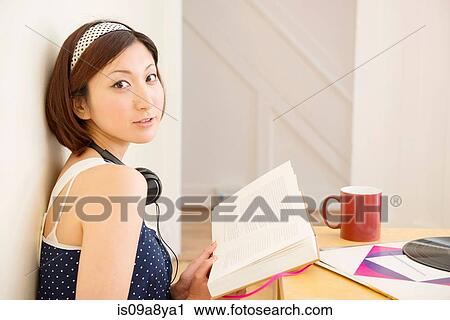 Woman looking up from book View Large Photo Image Stock Image - Woman looking up from book. Fotosearch