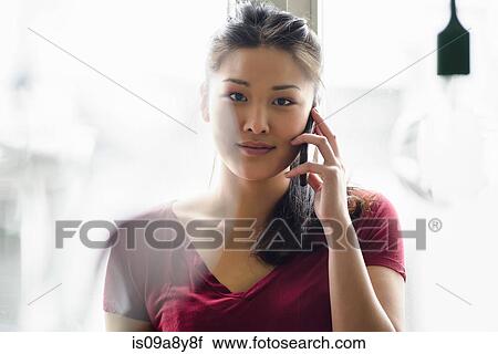 Woman on mobile phone looking at camera View Large Photo Image Stock Image - Woman on mobile phone looking at camera. Fotosearch