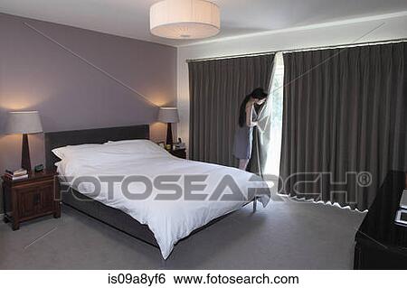 Woman peeping behind bedroom curtain View Large Photo Image Stock Photograph - Woman peeping behind bedroom curtain. Fotosearch