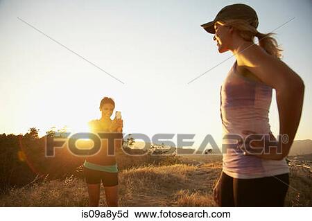 Stock Image - Woman photographing friend. Fotosearch