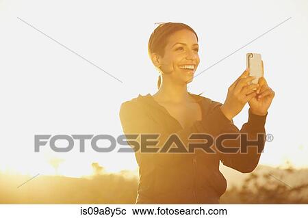 Stock Image - Woman photographing scenery. Fotosearch