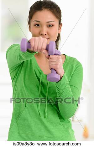 Woman punching with dumbbells in hand View Large Photo Image Picture - Woman punching with dumbbells in hand. Fotosearch