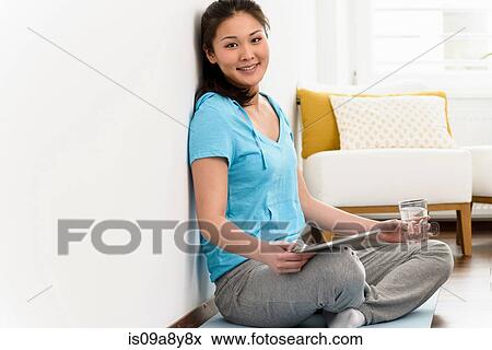 Woman resting digital tablet and glass on lap View Large Photo Image Stock Photo - Woman resting digital tablet and glass on lap. Fotosearch