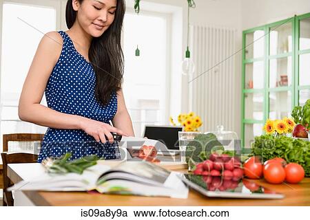 Stock Image - Woman slicing tomatoes. Fotosearch