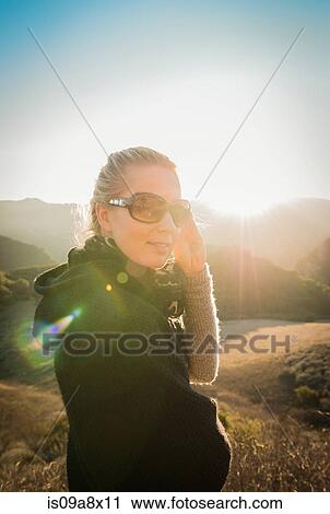 Stock Image - Woman standing in hills. Fotosearch