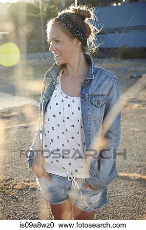 Stock Image - Woman standing in industrial area. Fotosearch
